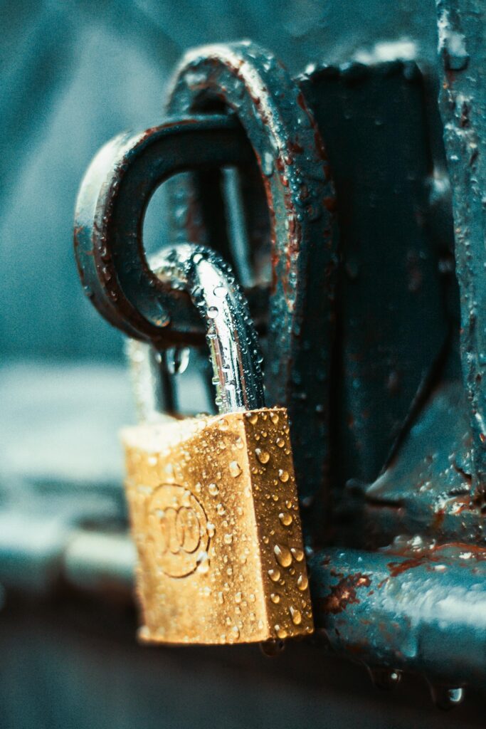 pexels-photo-1068349-1068349 A detailed shot of a wet padlock on a rusty metal surface, showcasing textures and water droplets.