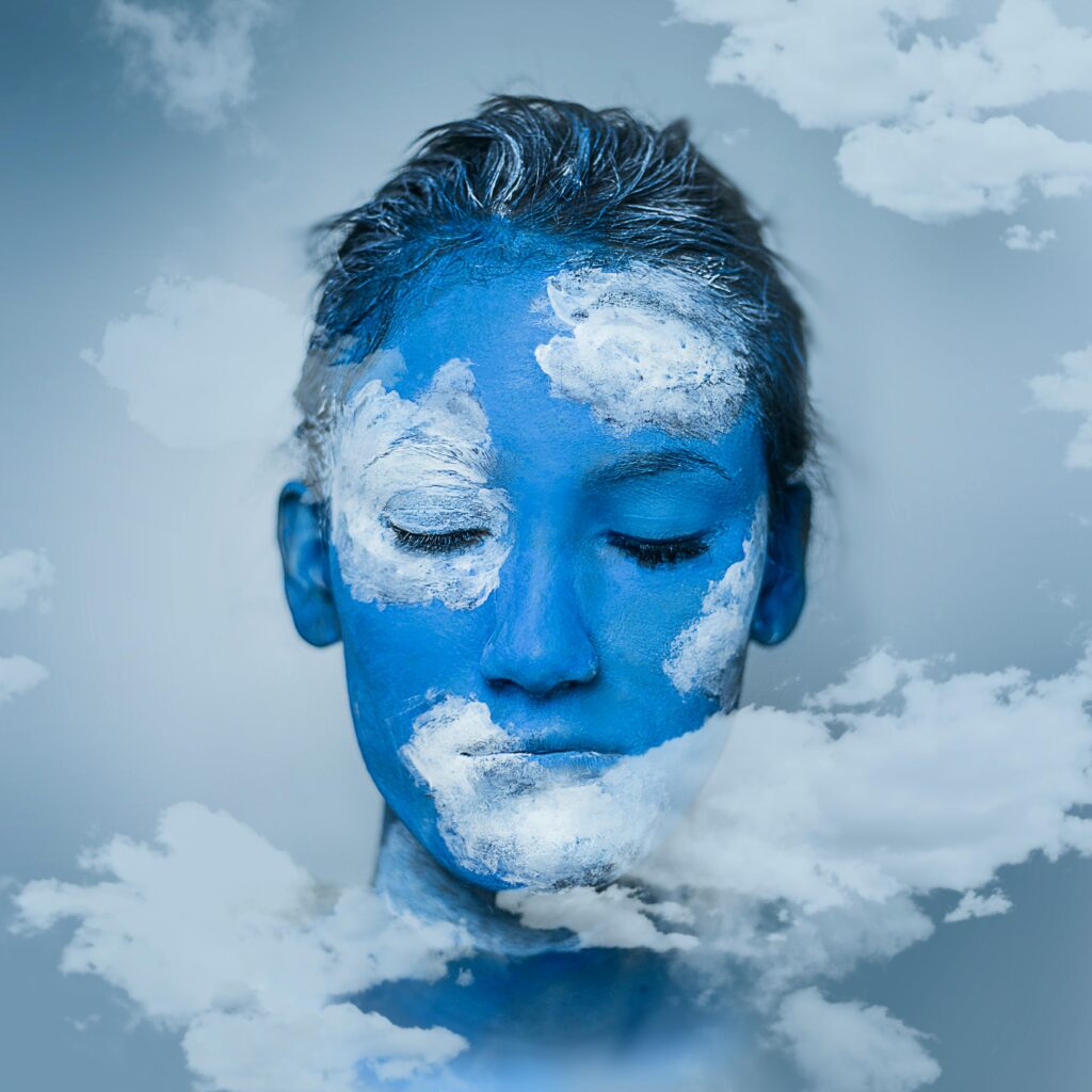 cloud services Creative portrait featuring blue and white face paint resembling skies and clouds for a dreamy effect.